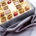 Geschenkbox mit verschiedenen Gourmet-Schokoladentrüffeln auf silbernem Seidenstoff.