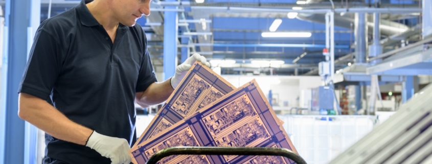Arbeiter bei der Inspektion einer Leiterplatte in einer Leiterplattenfabrik